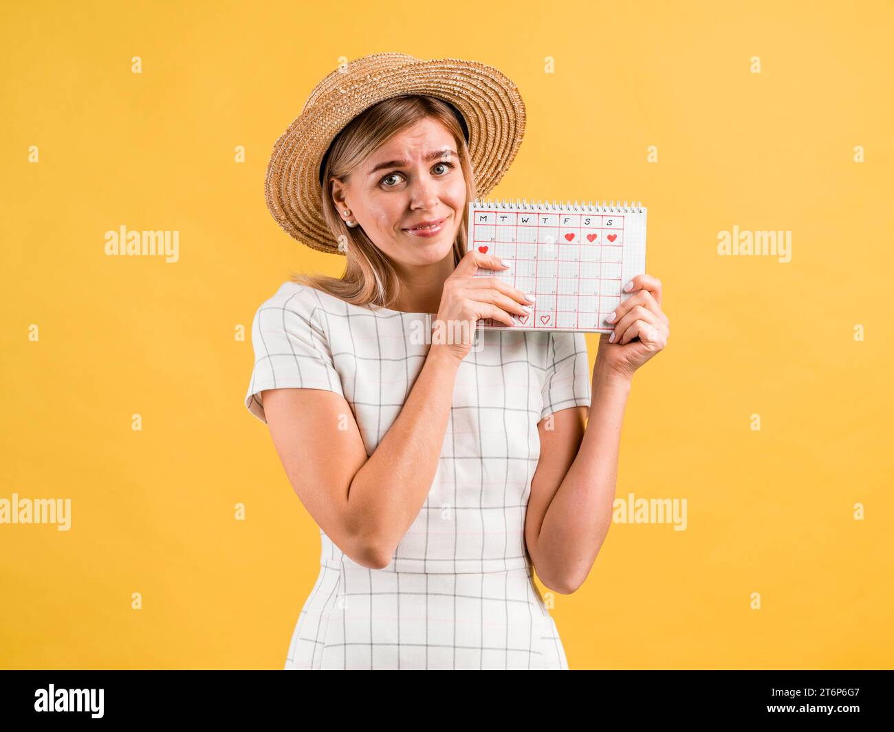 Belle jeune femme avec chapeau tenant calendrier de période Banque D'Images