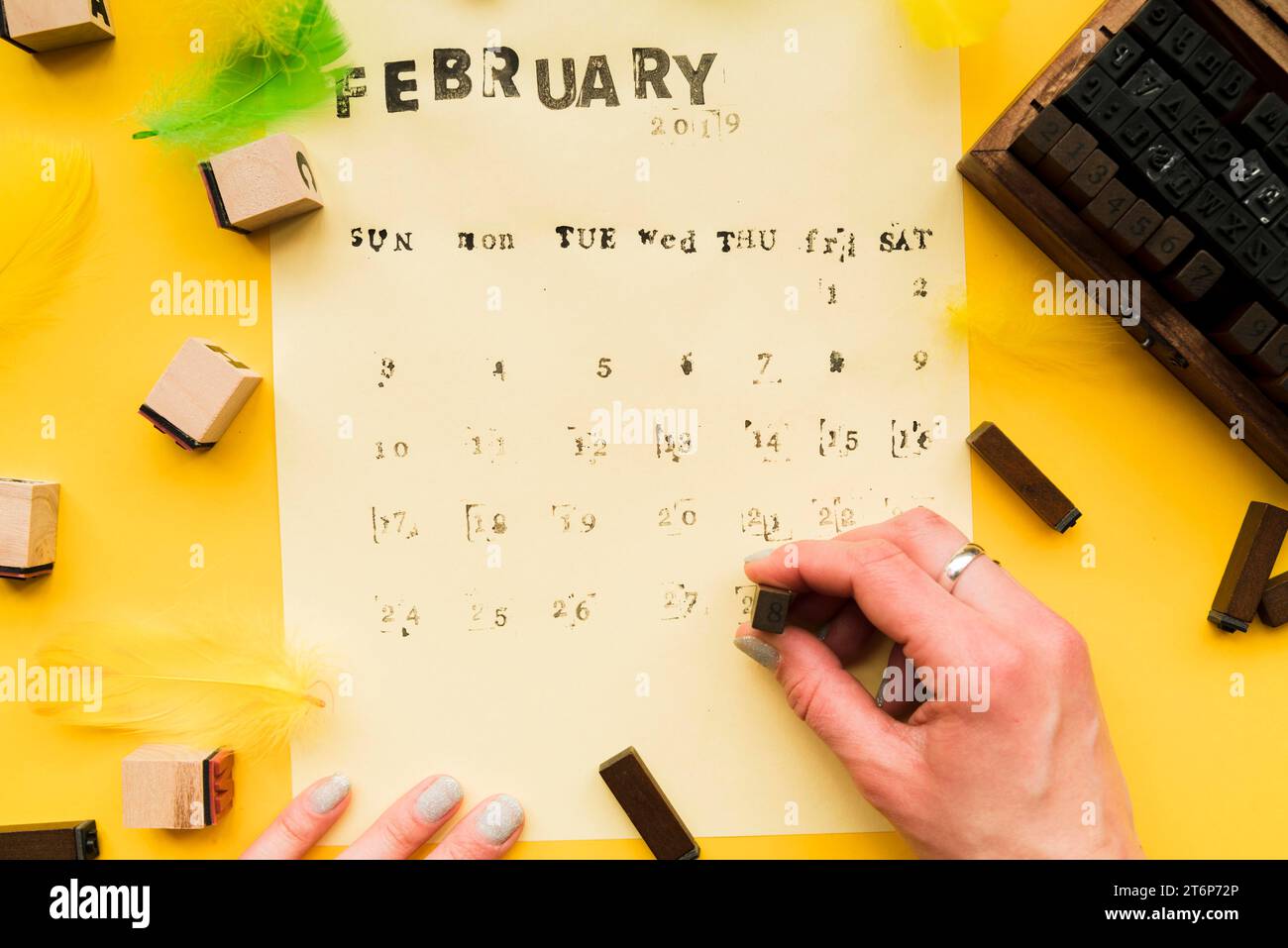 Gros plan la main de la personne faisant le calendrier de février fait à la main avec des blocs typographiques Banque D'Images