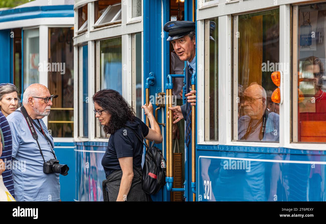 DAS Zürcher Tram - Elefant Ein Kontrolleur schaut ob alle Passagiere eingestiegen sind. DAS war in der Zeit des trams StStZ ce 4/4 321, welches 1930 an die Städtische Strasssenbahn Zürich abgeliefert wurde üblich. Besser bekannt ist das Tram unter dem Übername Elefant . 1966 wurde es ausrangiert und steht seit 1975 als Museumstram im Dienst der VBZ. Hier ist es auf der Linie 6 zwischen Zürich Hauptbahnhof und dem Zürich Zoo, anlässlich des Jubiläumsevents 175 Jahre Eisenbahn in der Schweiz im Einsatz. Zürich, Schweiz, 21.05.2022 *** le tramway de Zurich Elefant un inspecteur vérifie si tous Banque D'Images