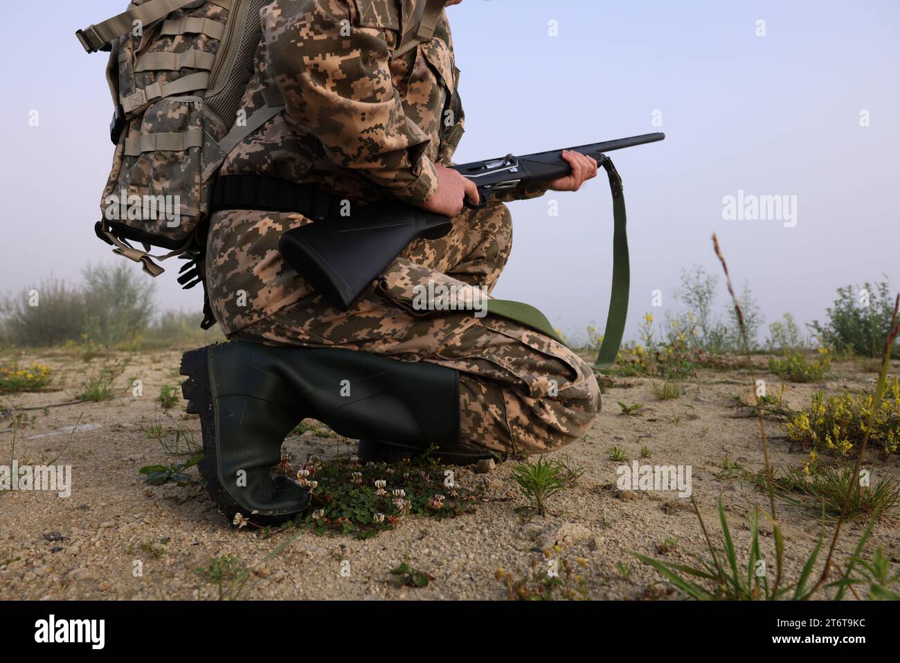 Homme portant le camouflage avec fusil de chasse et sac à dos à l'extérieur, gros plan Banque D'Images
