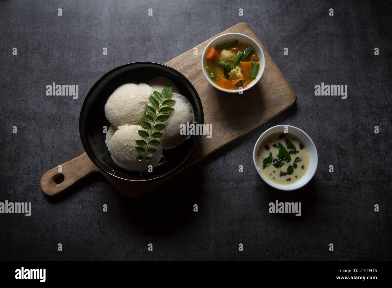 Snacks populaires de l'Inde du Sud idli sambar ou idly sambhar préparé en fumant du riz fermenté et servi avec trempette à la noix de coco et soupe de légumes ou sambar. Banque D'Images