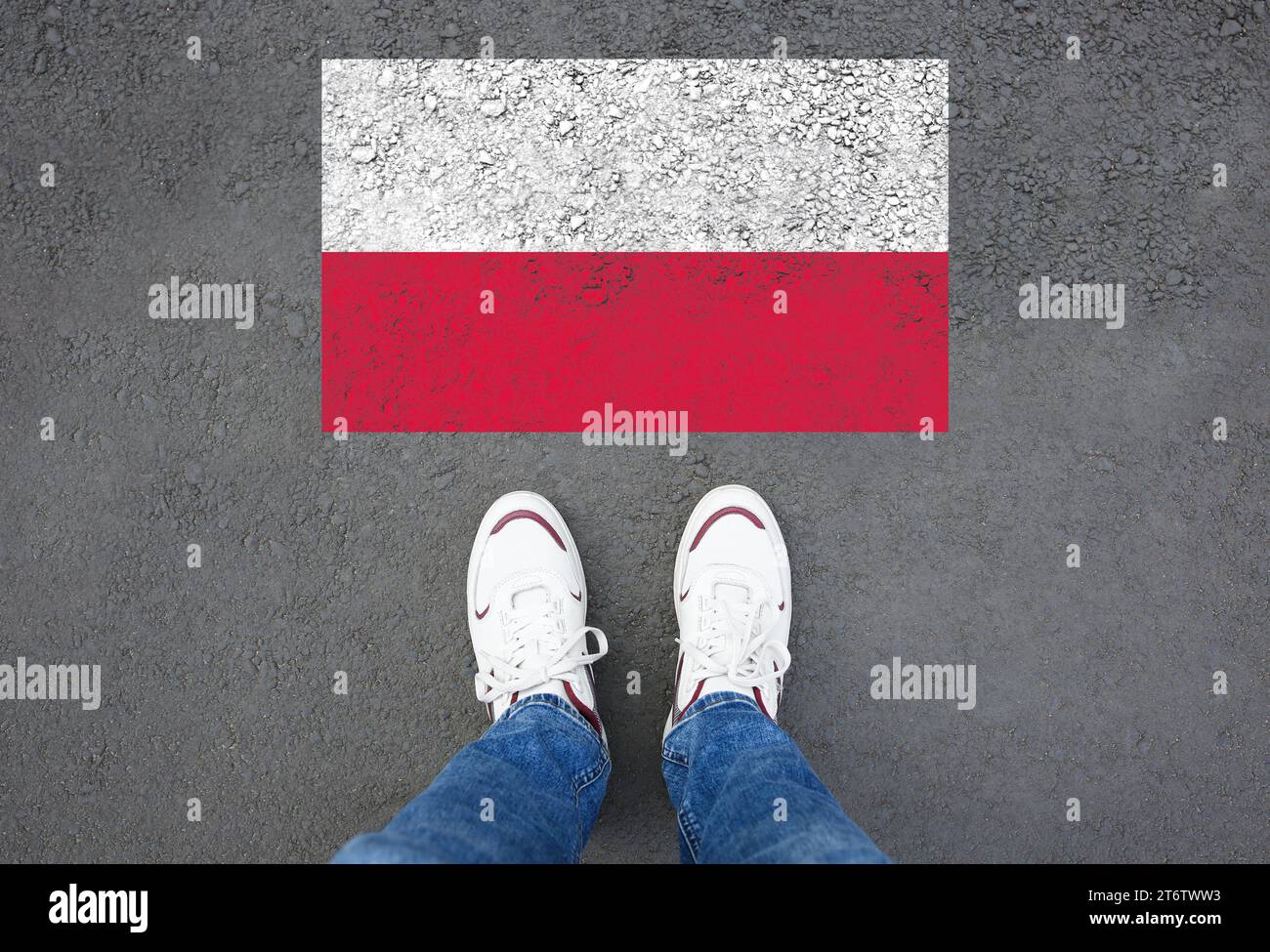 Immigration. Homme debout sur l'asphalte près du drapeau de la Pologne, vue de dessus Banque D'Images