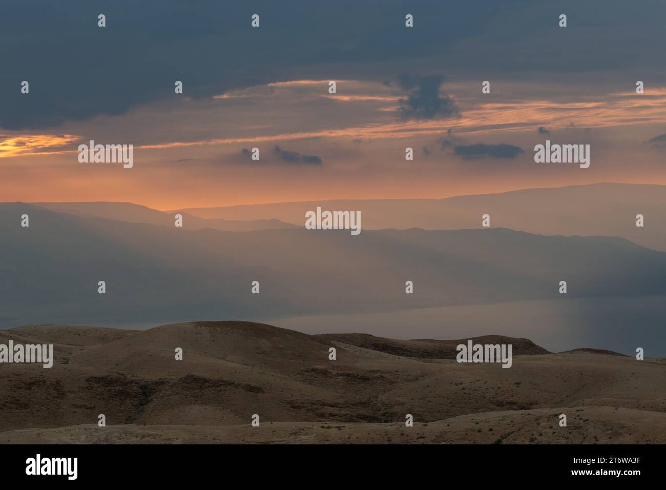 Lever du soleil au-dessus de la mer Morte et du désert de Judée en Israël avec les montagnes de Jordanie visibles en arrière-plan. Banque D'Images