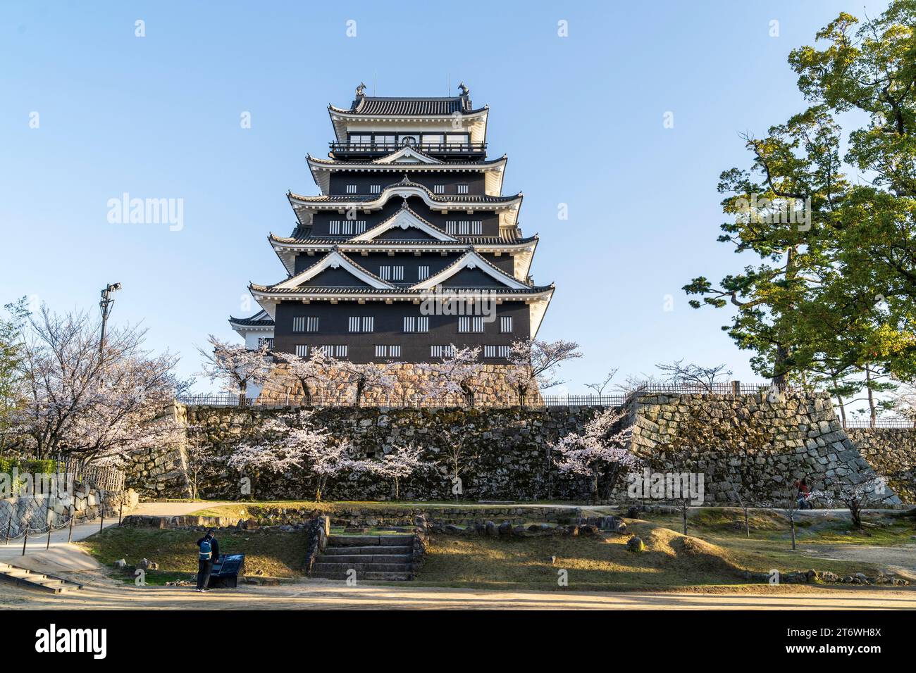 Château de Fukuyama, Japon. Le côté nord de la borogata garde avec son revêtement en plaque de fer noir sur une journée de printemps avec des fleurs de cerisier et un ciel bleu. Banque D'Images