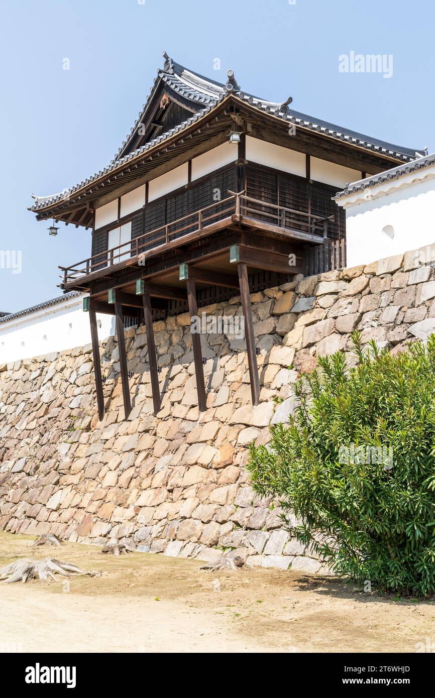 Château de Fukuyama au Japon. Les bains publics Yudono en bois reconstruits perchés au sommet des murs de pierre ishigaki de style uchikomihagi avec un ciel bleu derrière Banque D'Images