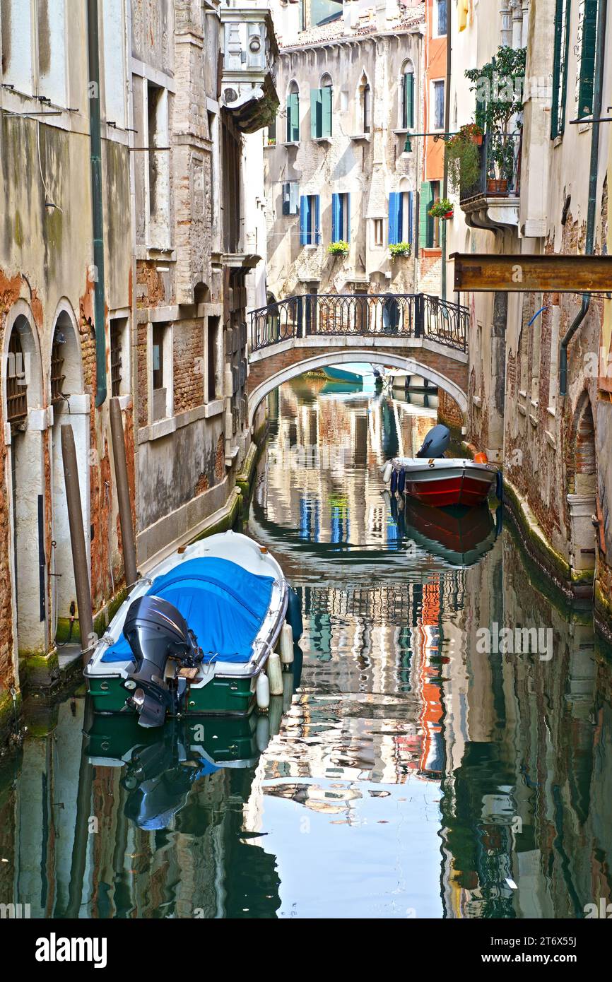 Canal ensoleillé à Venise avec des bateaux garés autour Banque D'Images