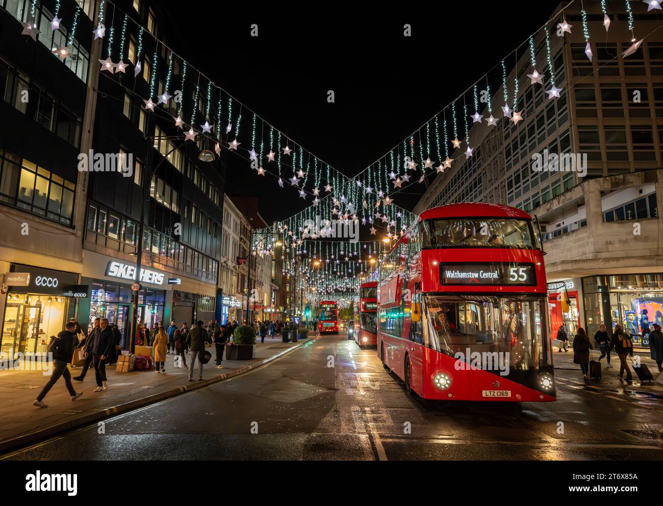 Londres, Royaume-Uni - novembre 8 2023 : Oxford Street, une célèbre rue commerçante du centre de Londres avec des lumières de Noël et des bus rouges de Londres. Banque D'Images