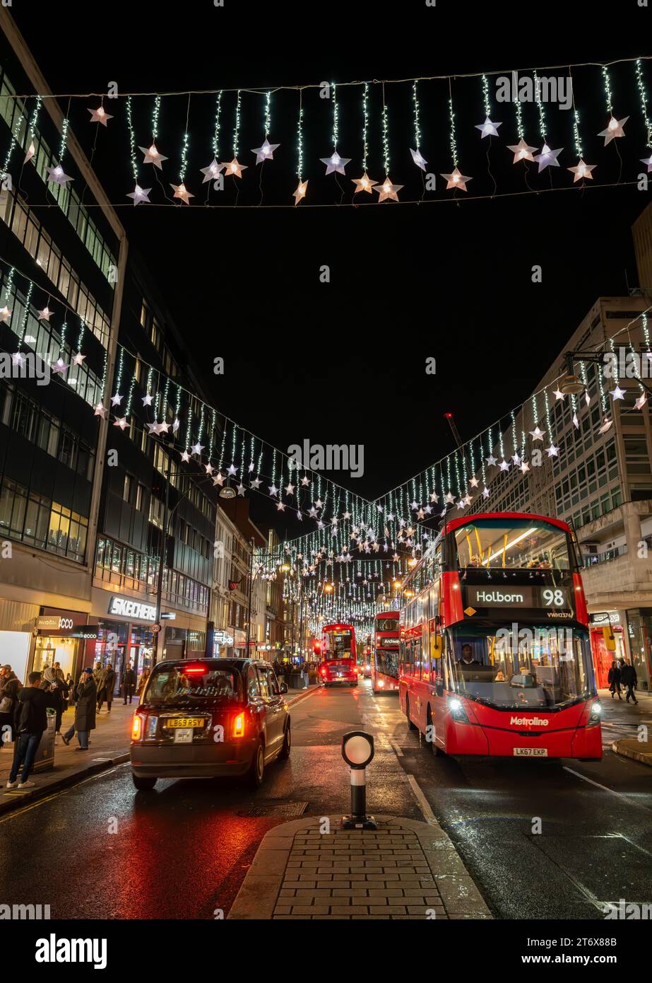 Londres, Royaume-Uni - novembre 8 2023 : Oxford Street, une célèbre rue commerçante du centre de Londres avec des lumières de Noël et des bus rouges de Londres. Banque D'Images