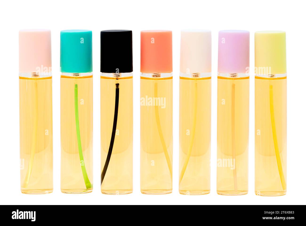 Bouteille en verre de parfum avec des couvercles multicolores dans une rangée sur un fond blanc Banque D'Images