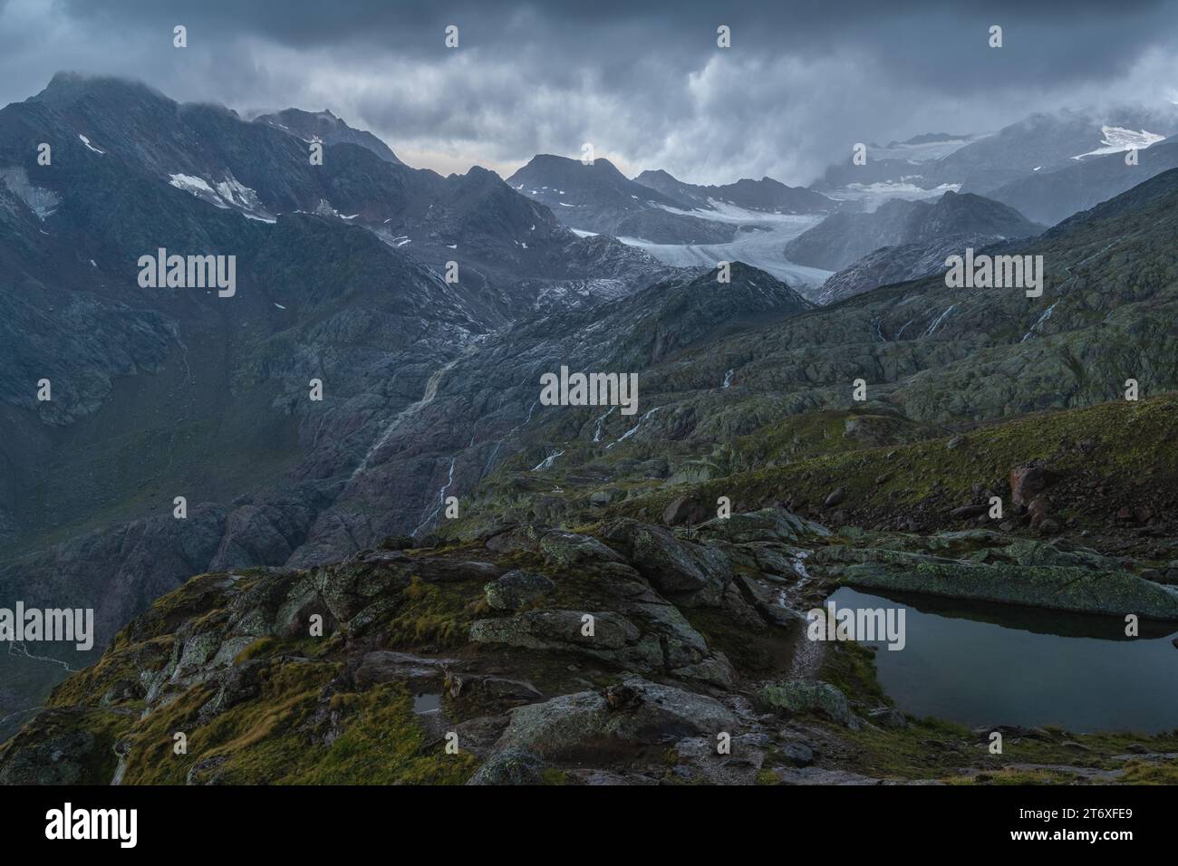 Tempête de pluie dans les montagnes, mauvais temps alpin sur le glacier et sommets sombres. Pluie coulant sur les pentes. Banque D'Images