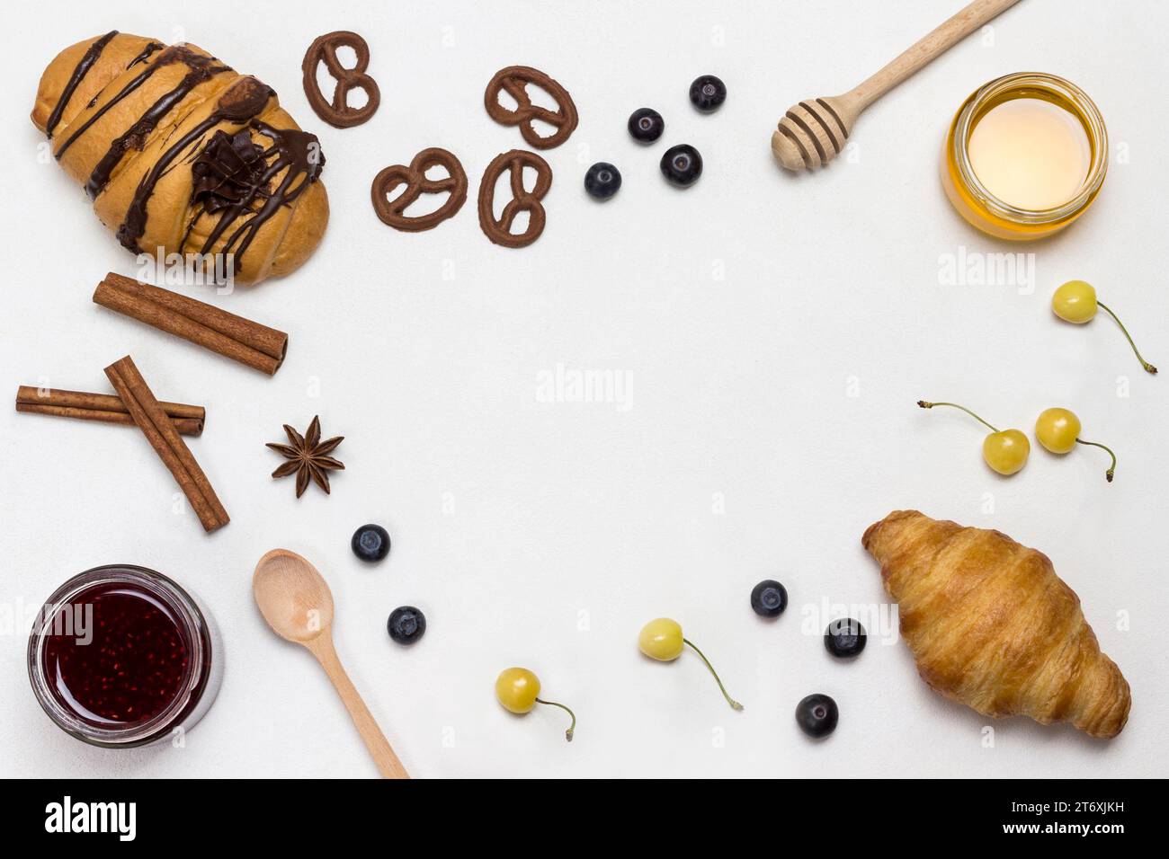 Croissants et biscuits figurés, baies, abricots miel, confiture, cannelle. Ensemble de produits pour le petit déjeuner nutritif. Fond blanc. Plat, copie spa Banque D'Images