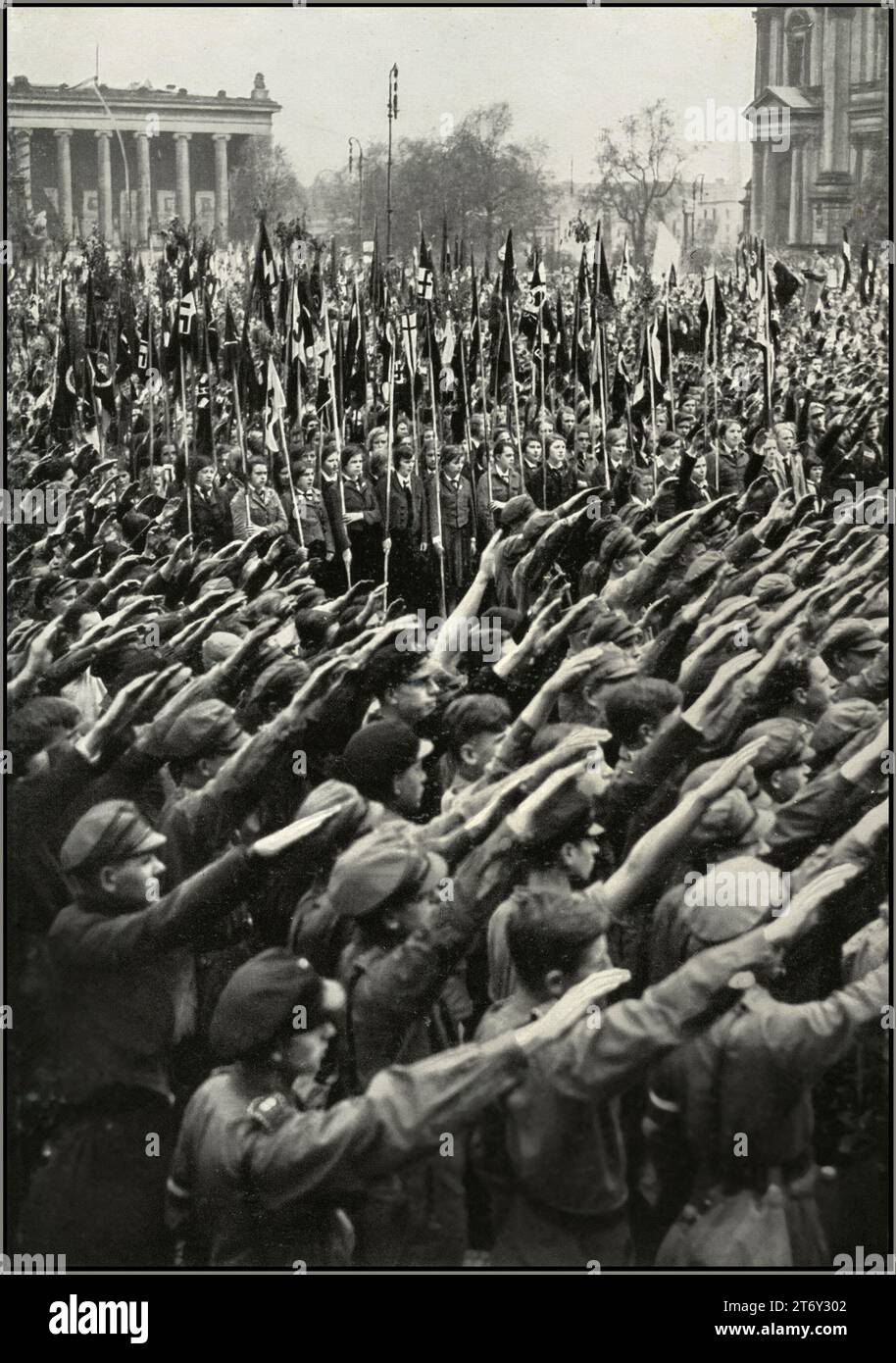 Rassemblement de la jeunesse de l'Allemagne nazie des années 1930 dans le jardin de plaisance de Berlin, avec drapeau swastika portant la Ligue des filles allemandes BDM et HitlerJugend Hitler Youth donnant au parti nazi Heil Hitler salut à Fuhrer Adolf Hitler. « L'Allemagne réveille » la montée du nazisme en Allemagne des années 1930 Banque D'Images
