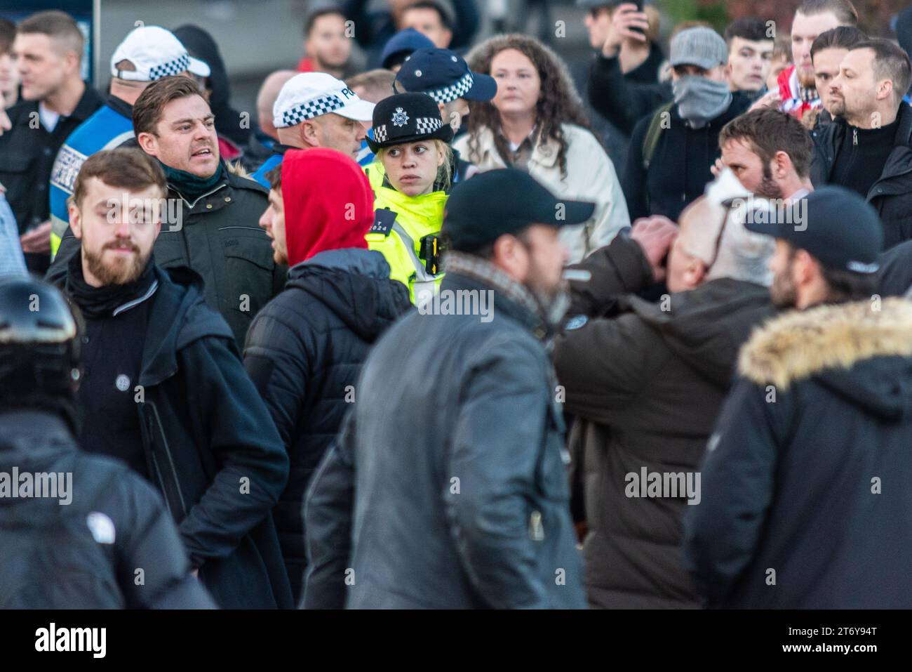 Une femme policière inquiète parmi les manifestants marqués comme étant d'extrême droite tentant d'arrêter une manifestation pro Palestine à Londres, au Royaume-Uni, le jour de l'Armistice Banque D'Images