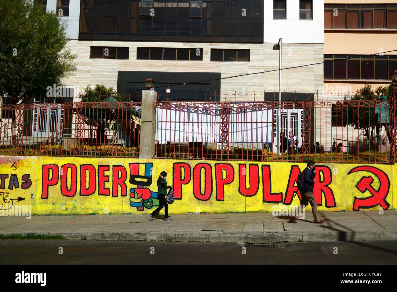 Les gens passent devant une murale Poder Popular / Power to the People du Parti communiste bolivien près de la principale université UMSA dans le centre de la Paz, en Bolivie Banque D'Images