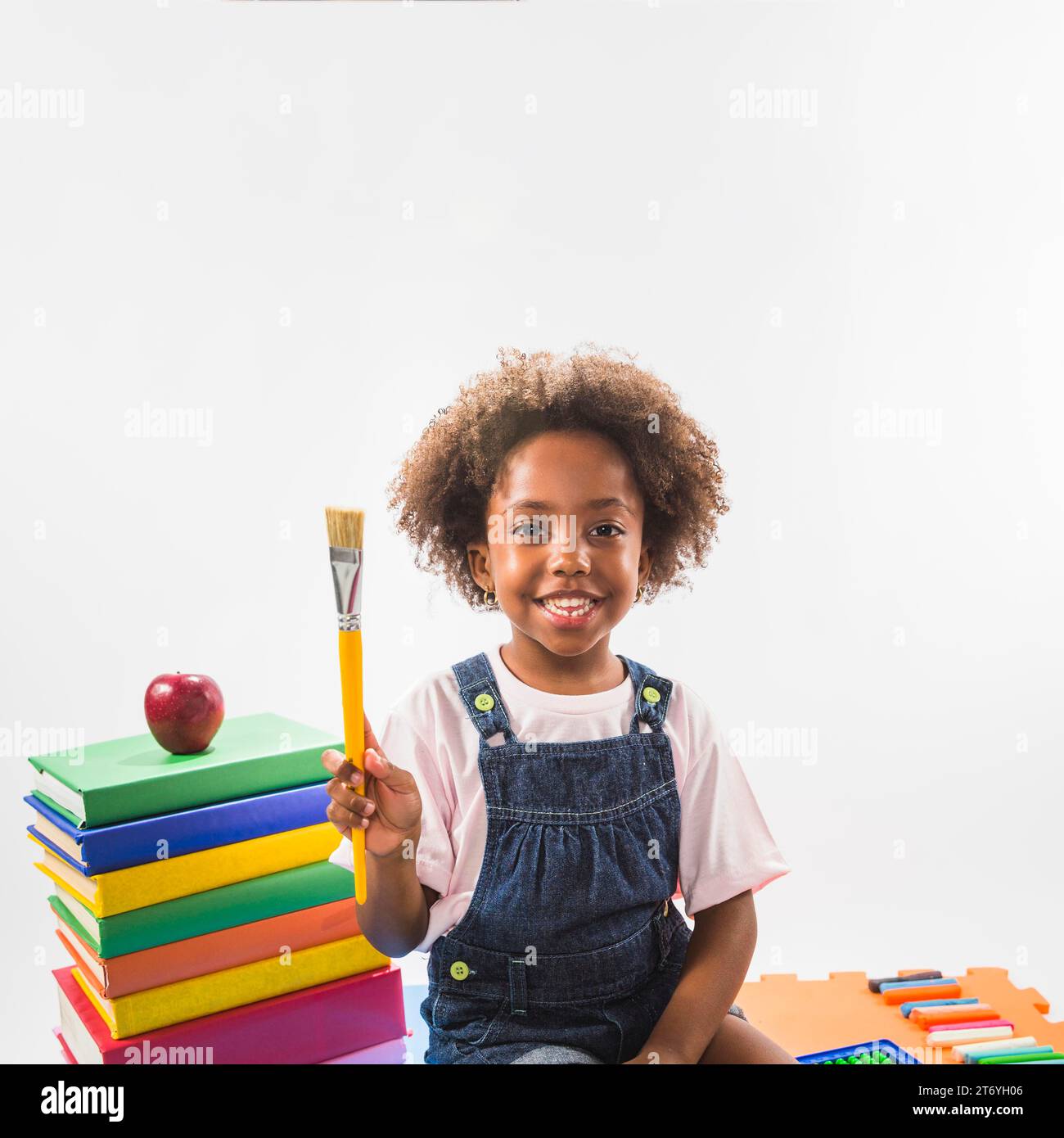 Enfant avec le studio de livres de pinceau Banque D'Images