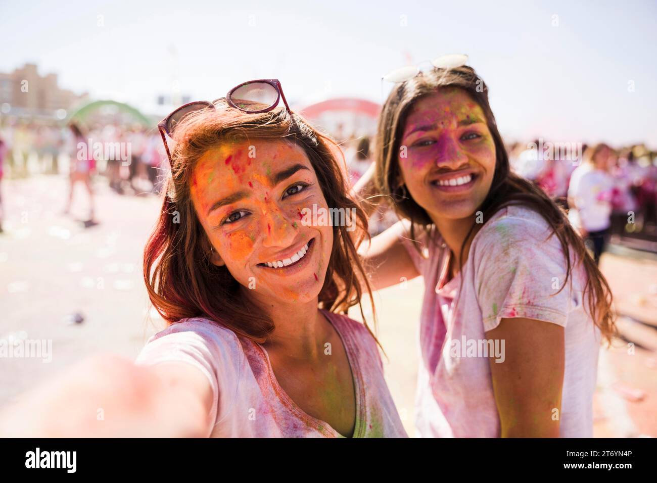 Jeune femme souriante prenant selfie avec son ami Holi Banque D'Images