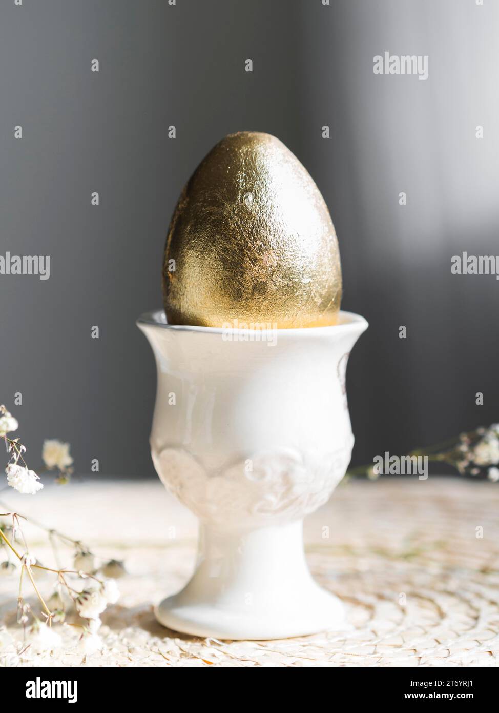 Vue de face porte-oeufs dorés de pâques avec gypsophila Banque D'Images