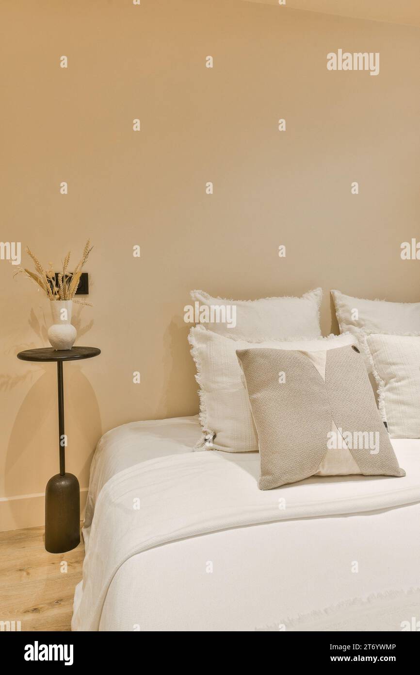 un lit dans une chambre avec des draps blancs et des oreillers sur le bedspremnwhitt, pris d'en haut Banque D'Images