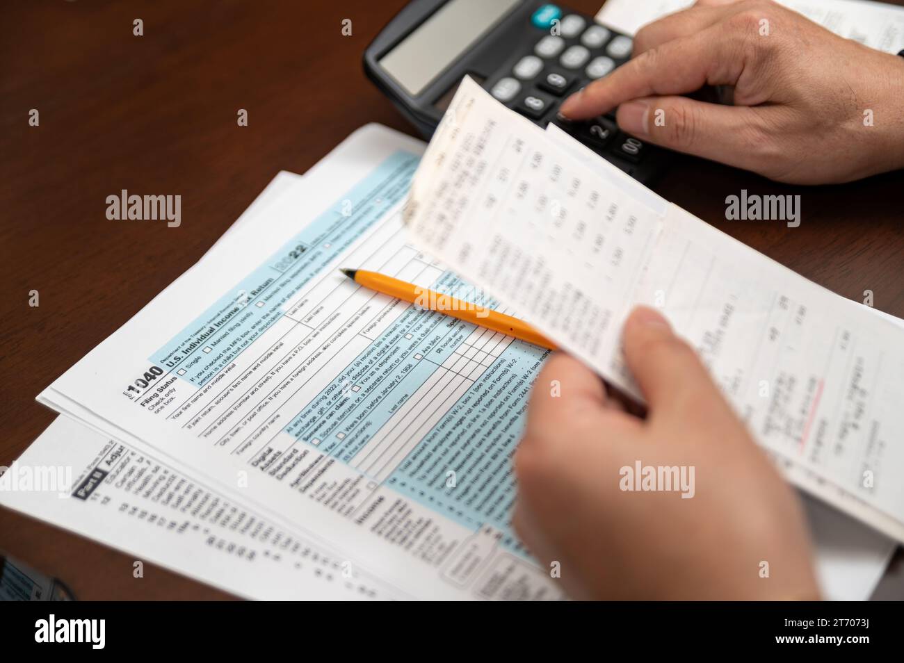 Un homme qui organise la déclaration de revenus individuelle 1040 et les reçus. Arrière-plan flou. Temps fiscal.concept fiscal. Gros plan. Banque D'Images