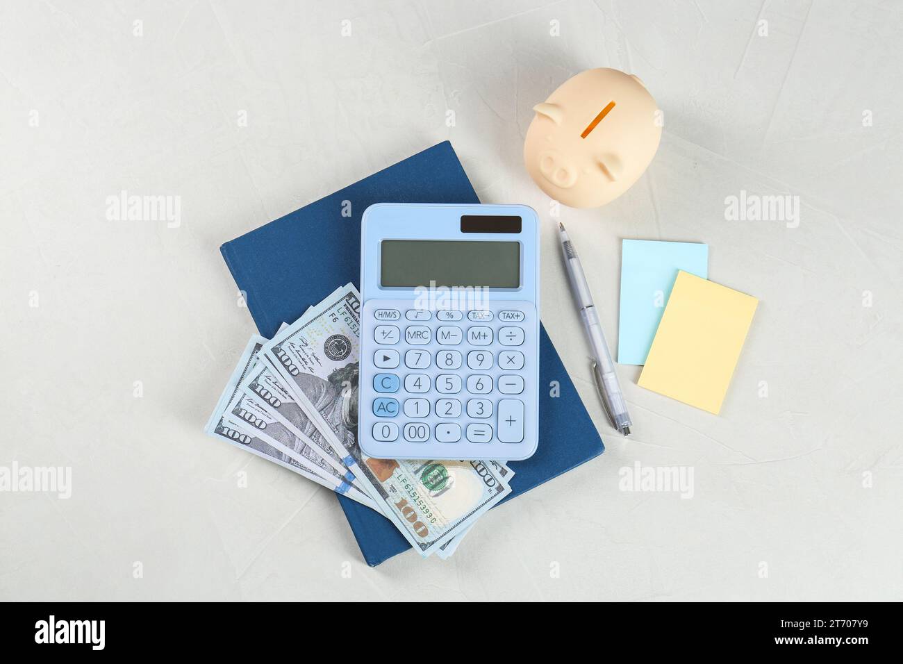 Calculatrice, billets de banque en dollars, cahier, stylo, notes autocollantes et tirelire sur table gris clair, mise à plat. Concept de retraite Banque D'Images