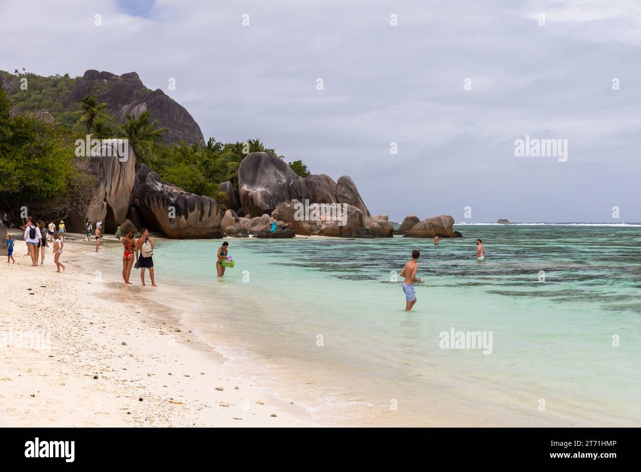La Digue, Seychelles - 16 août 2023 : paysage de plage d'Anse Union, les touristes sont à la côte près des rochers Banque D'Images