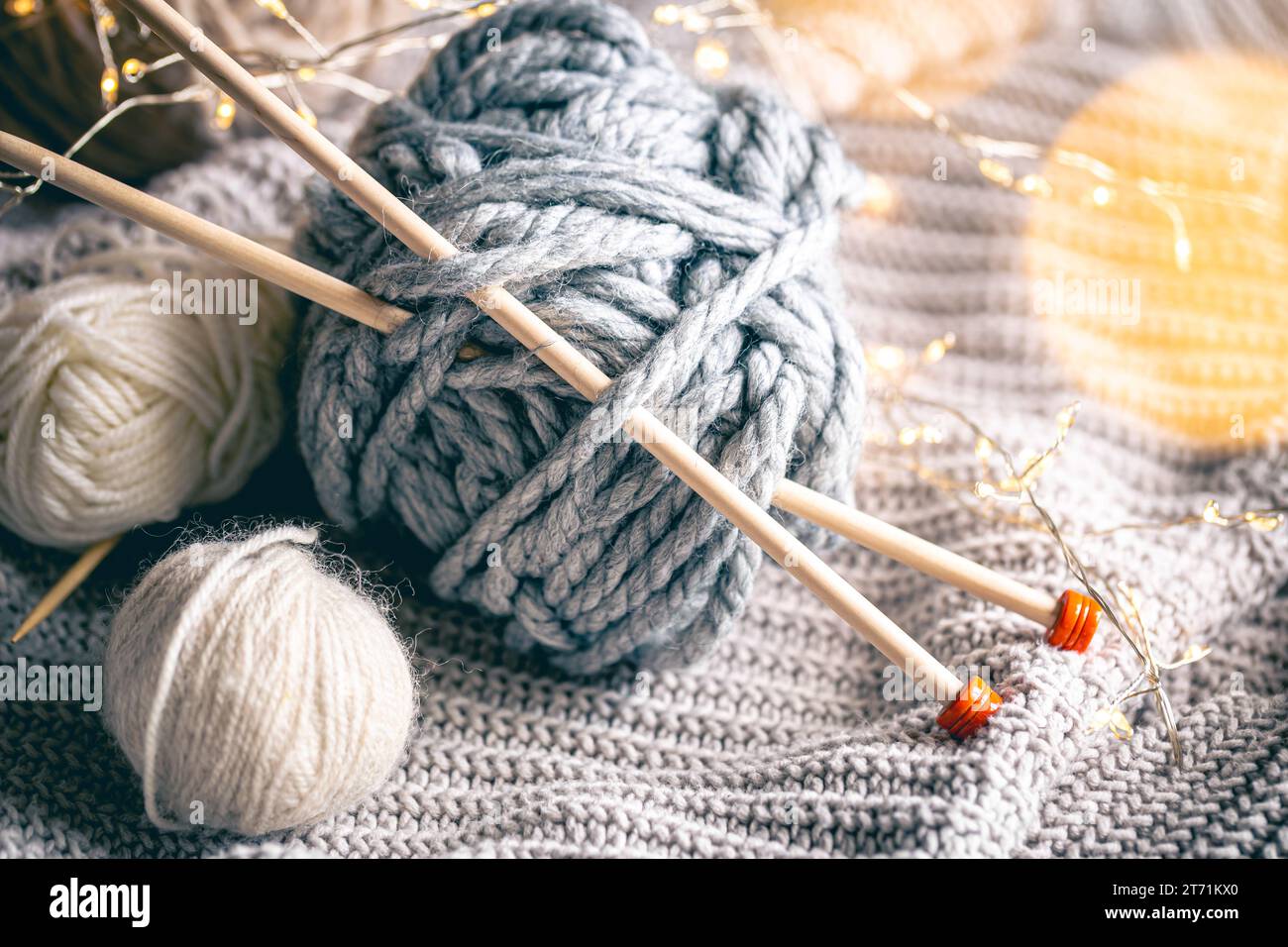 Fond confortable avec une boule de fil et des aiguilles à tricoter. Banque D'Images