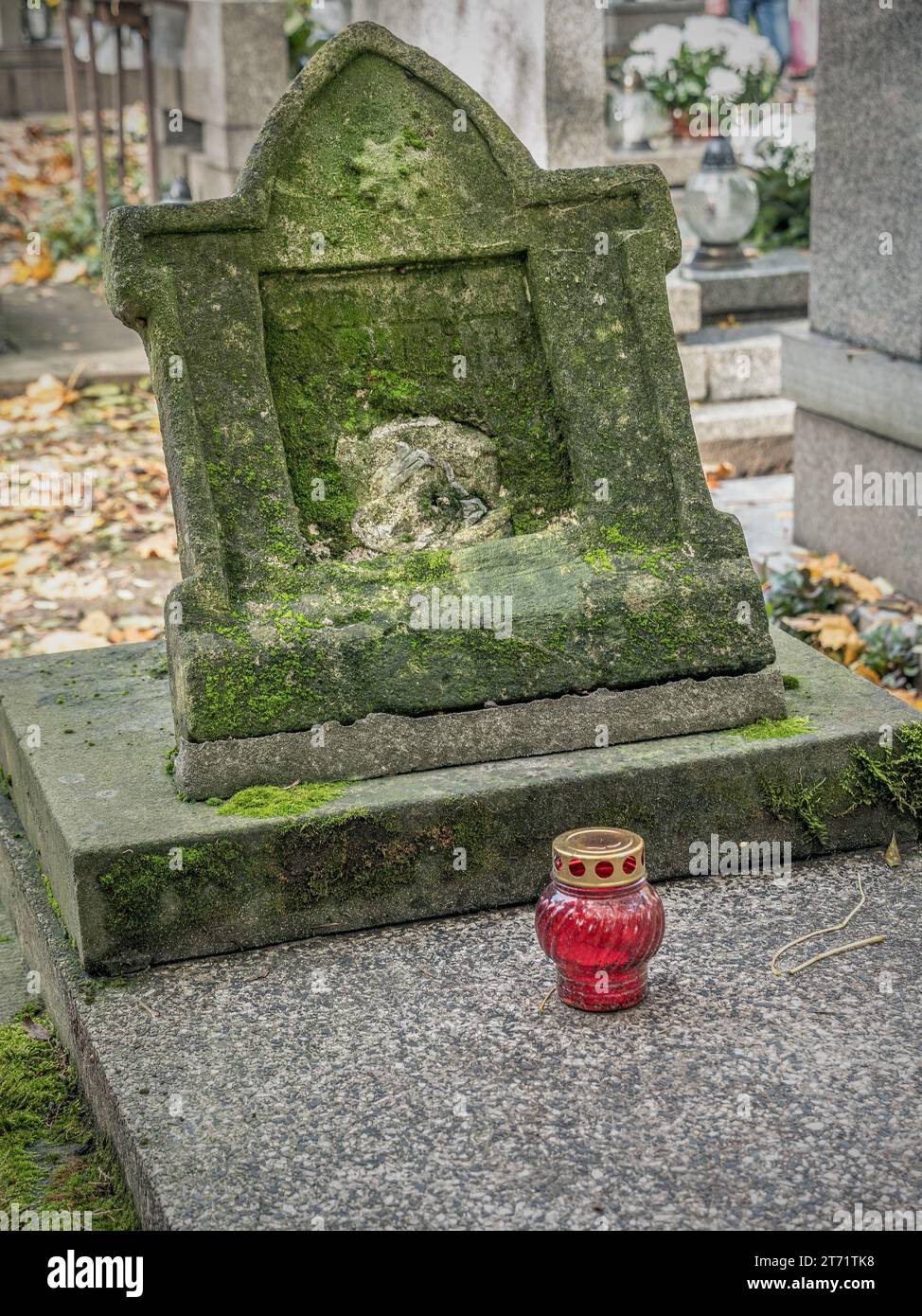 Vieille pierre tombale oubliée avec une bougie tombale votive Banque D'Images