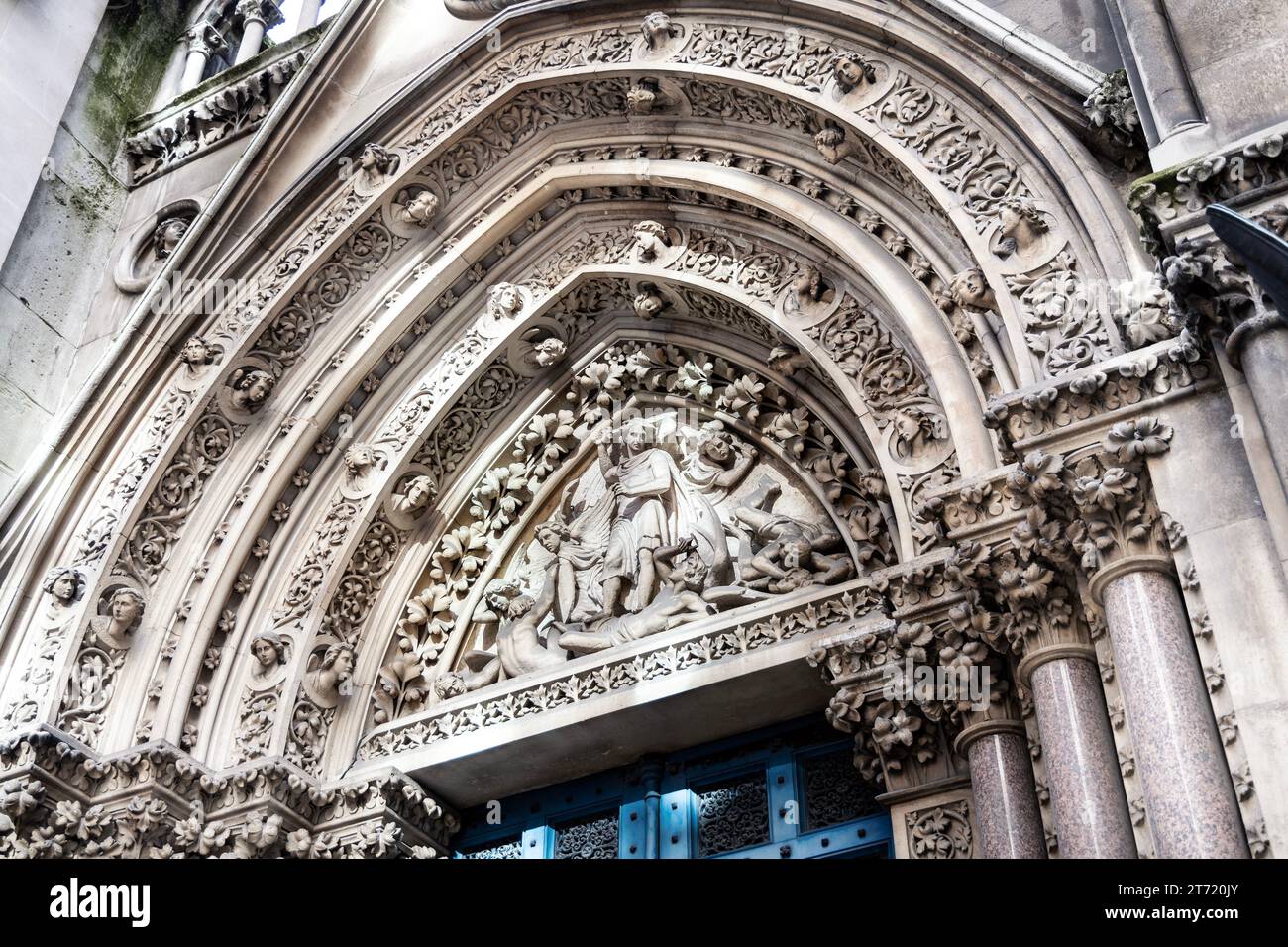 Sculpture d'archivolt et de tympan 'St Michael disputant avec Satan' de l'église St Michael's dans l'historique Square Mile, ville de Londres, Angleterre Banque D'Images