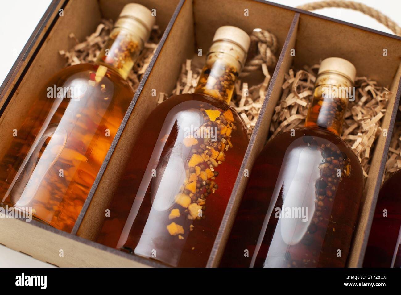 Bouteilles avec brandy de boisson alcoolisée maison chère et cognac dans une boîte en bois, gros plan. Banque D'Images