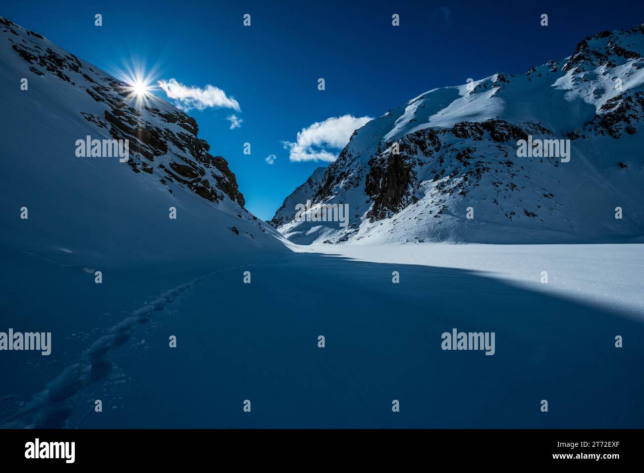 Pistes de raquettes dans un paysage de montagne ensoleillé d'hiver Banque D'Images