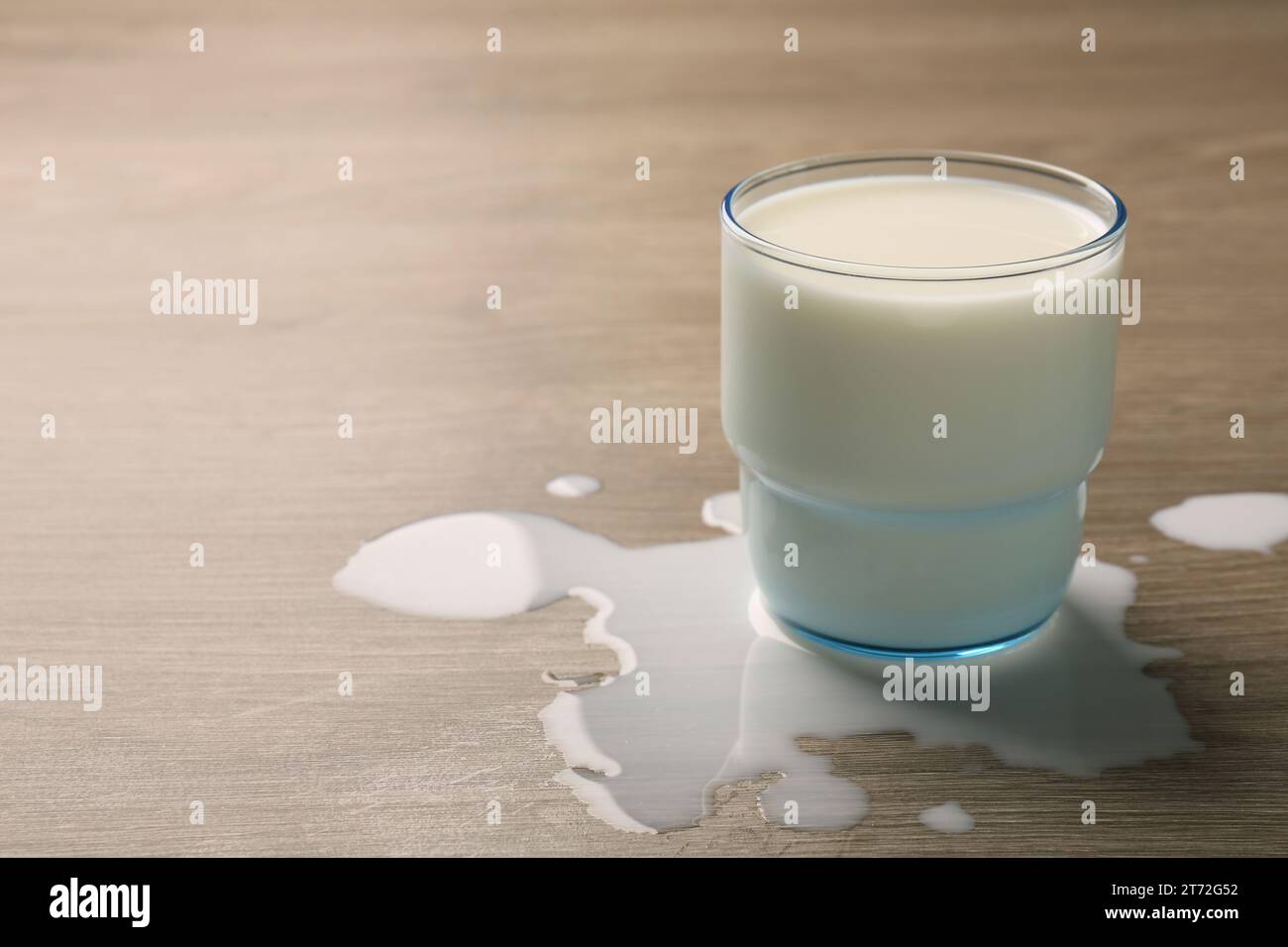 Lait renversé et verre de boisson sur la table en bois. Espace pour le texte Banque D'Images Lait renversé et verre de boisson sur la table en bois. Espace pour le texte Banque D'Images