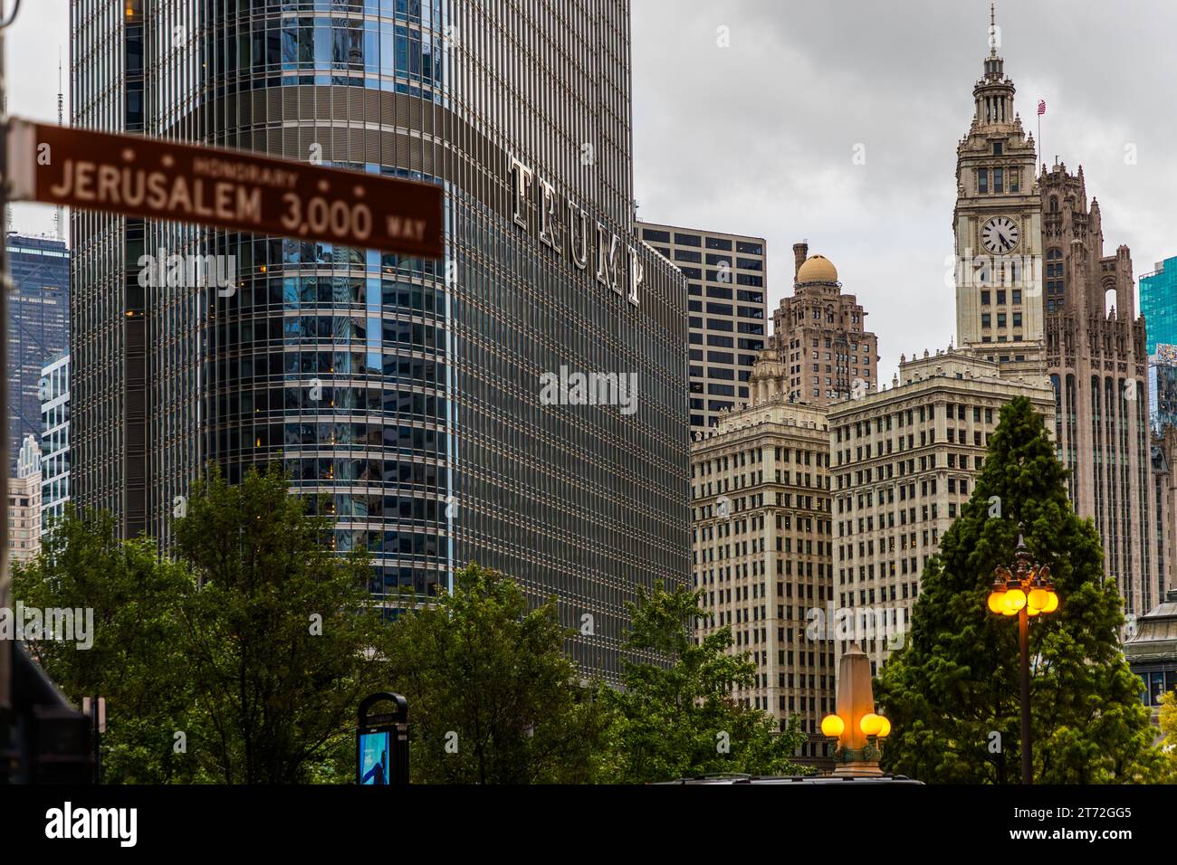 Un panneau de rue honorifique marron portant l'inscription "Jerusalem 3 000 Way" est accroché au bord de la route à Chicago, Illinois, États-Unis, nommé en l'honneur du 3 000e anniversaire de la conquête de Jérusalem par le roi David. En arrière-plan s'élève l'hôtel et tour Trump International en verre miroir avec son inscription "Trump", et à sa droite la tour d'horloge blanche du Wrigley Building à côté du clocher néo-gothique du Tribune Tower. Banque D'Images