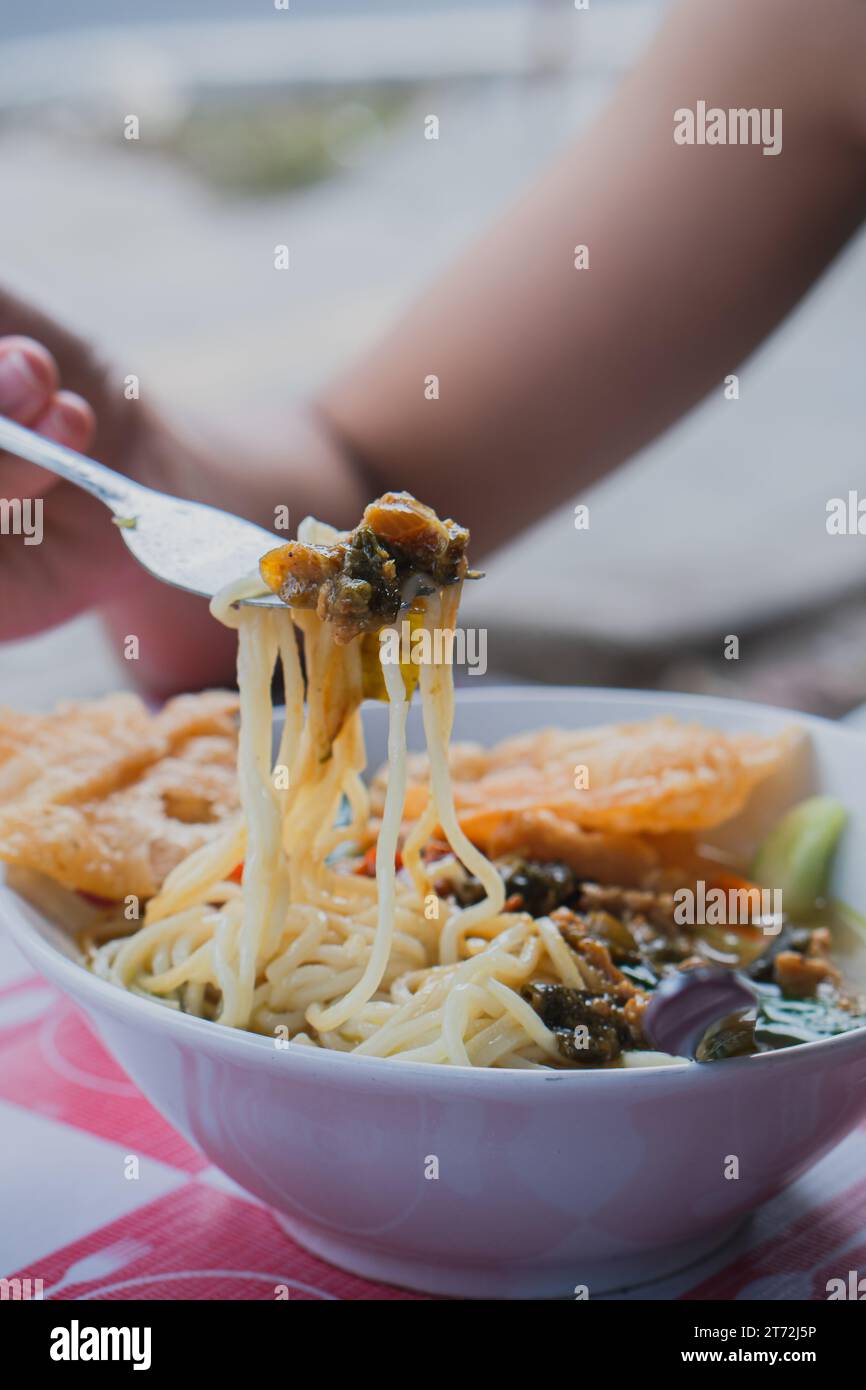 Femelle tirant des nouilles hors de la soupe ramen Banque D'Images