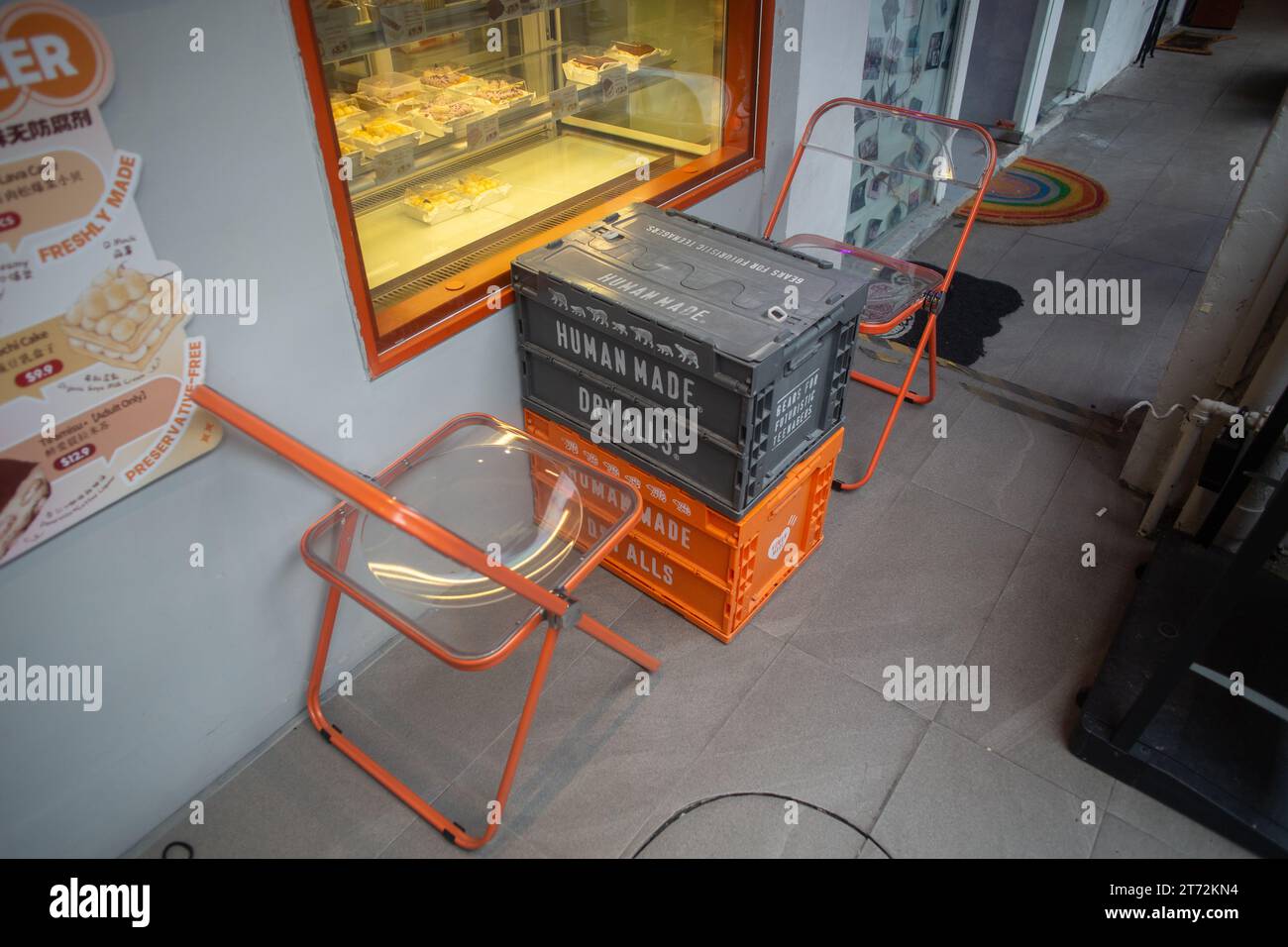 Caisses de stockage de marque fabriquées par l'homme 50 litres. En gris et orange est empilé devant une pâtisserie, Haji Lane, Singapour. Banque D'Images