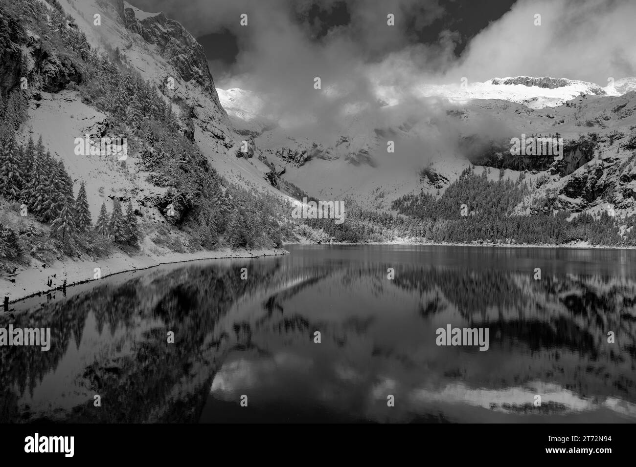 Montagnes enneigées et leur lac en noir et blanc Banque D'Images