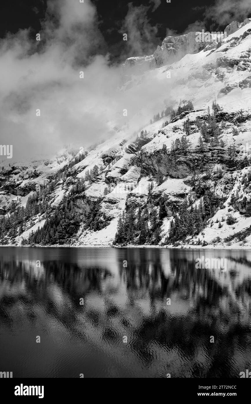 Montagnes enneigées et leur lac en noir et blanc Banque D'Images