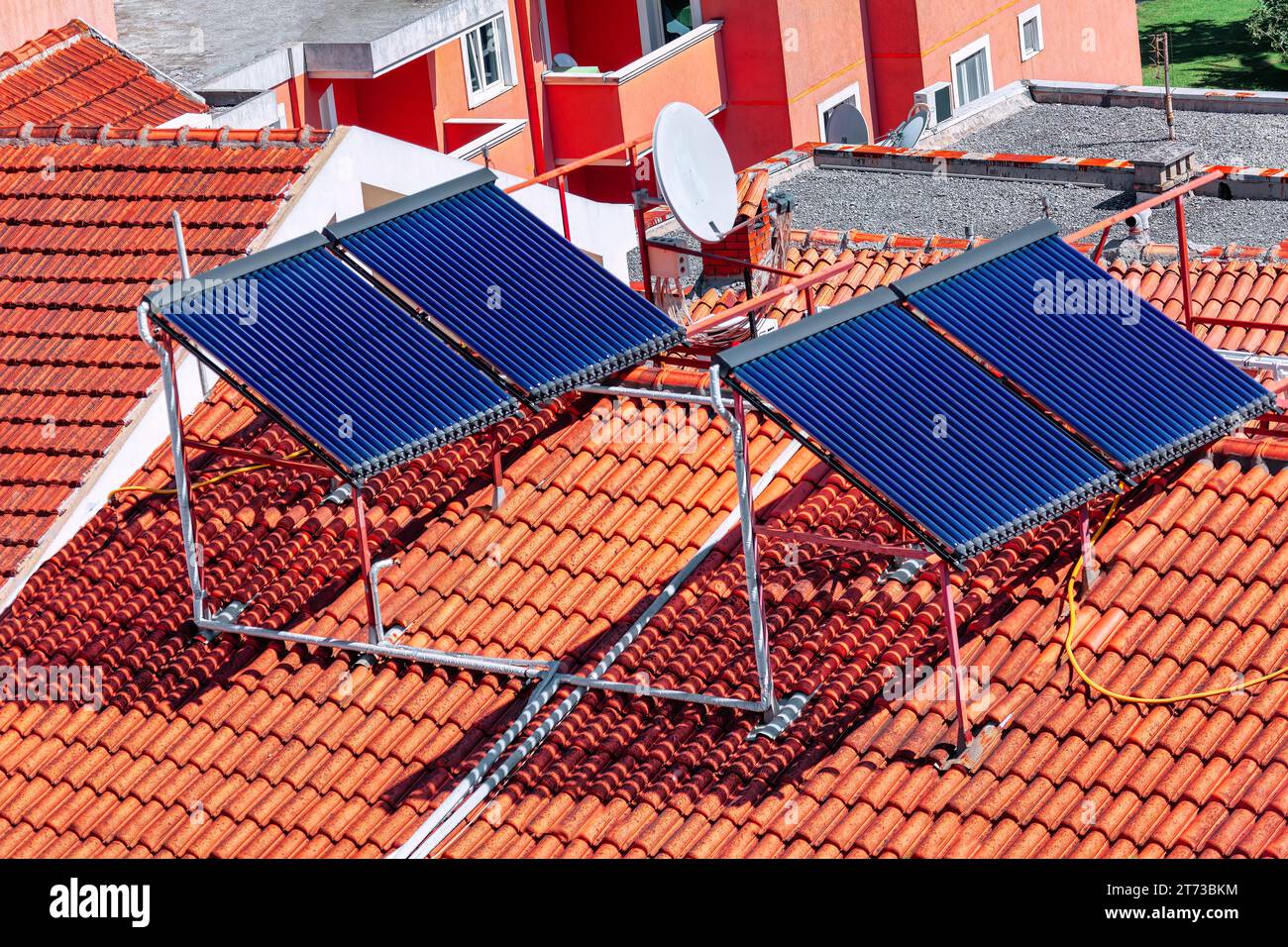 Capteurs solaires pour chauffer l'eau sur le toit. Des capteurs solaires ornent le toit en tuiles, le transformant en une centrale écologique pour le chauffage Banque D'Images