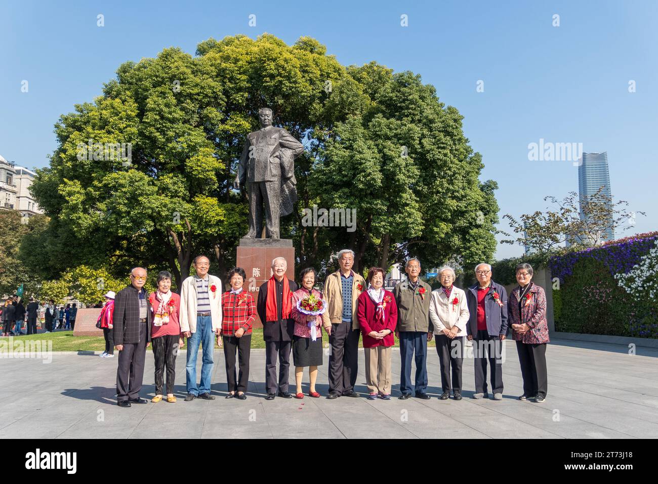 Des personnes âgées visitant Shanghai posent pour une photo de groupe devant une statue de Mao Tse Tong, en Chine. Banque D'Images