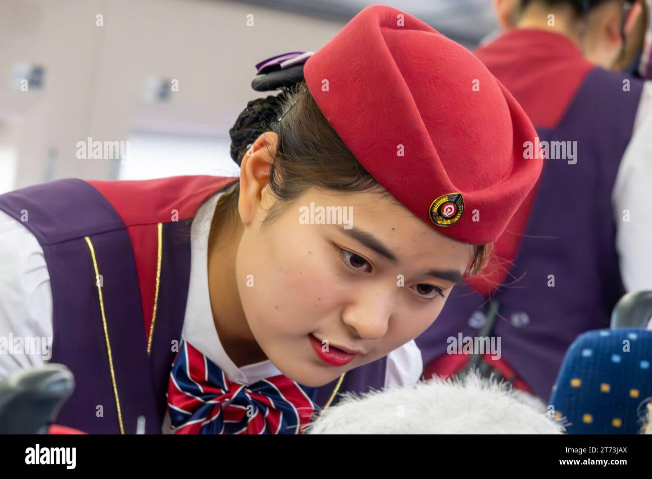 Hôtesse répondant à un client à bord d'un train à grande vitesse chinois (TGV). Banque D'Images