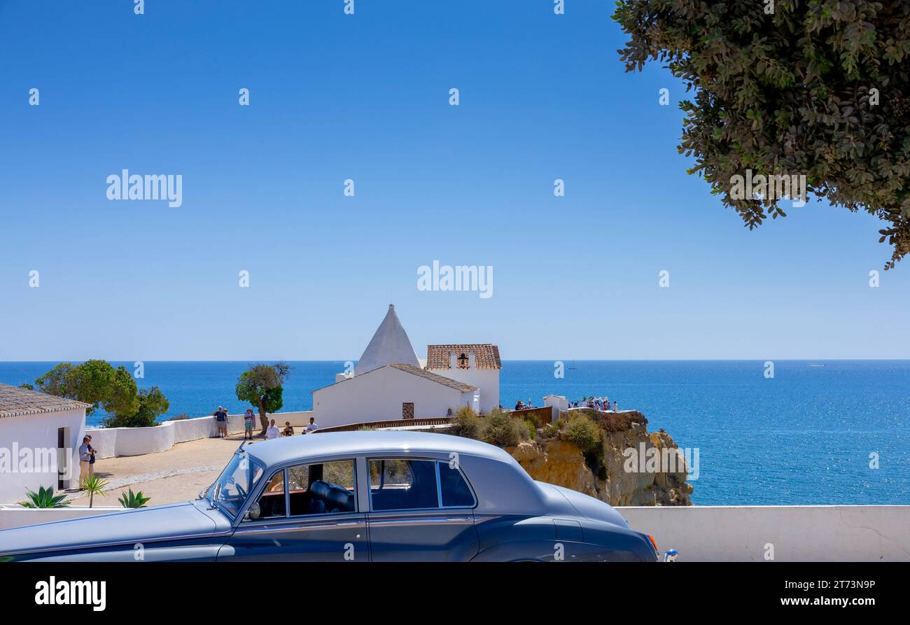 Algarve, Portugal - 13.09.2023 : vue sur une voiture classique bleue et la chapelle de notre-Dame du Rocher (Igreja Nossa Senhora da Rocha). Porches, Algarve Banque D'Images