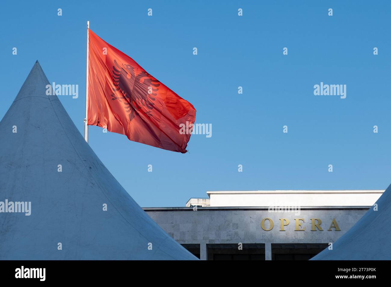 Le drapeau albanais au-dessus du bâtiment de l'opéra sur la place Skanderbeg, Tirana, Albanie Banque D'Images