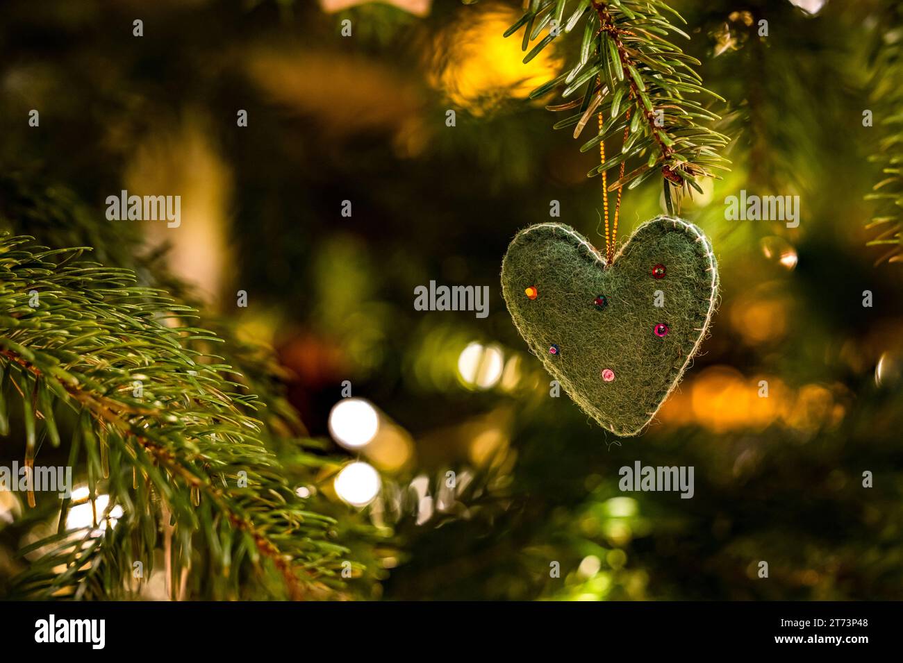 Un coeur en tissu avec des décorations sur le sapin de Noël dans la lumière d'ambiance pour Noël Banque D'Images Un coeur en tissu avec des décorations sur le sapin de Noël dans la lumière d'ambiance pour Noël Banque D'Images
