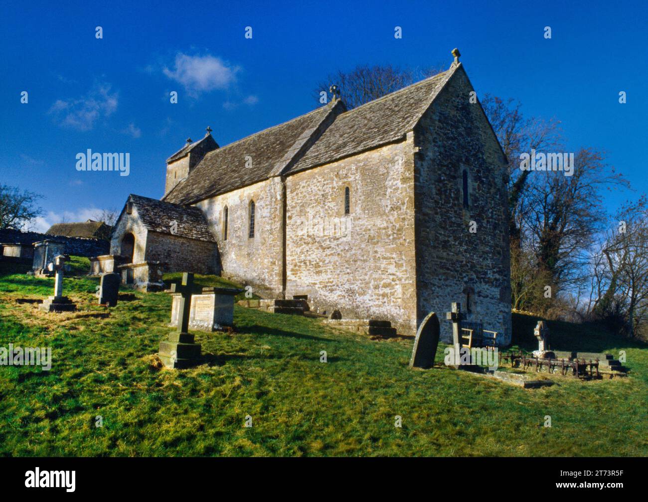 Vue au nord-ouest de l'église St Michael's construite sur une colline escarpée surplombant la vallée du ruisseau Dunt, Duntisbourne Rouse, Gloucestershire, Angleterre, Royaume-Uni. Banque D'Images