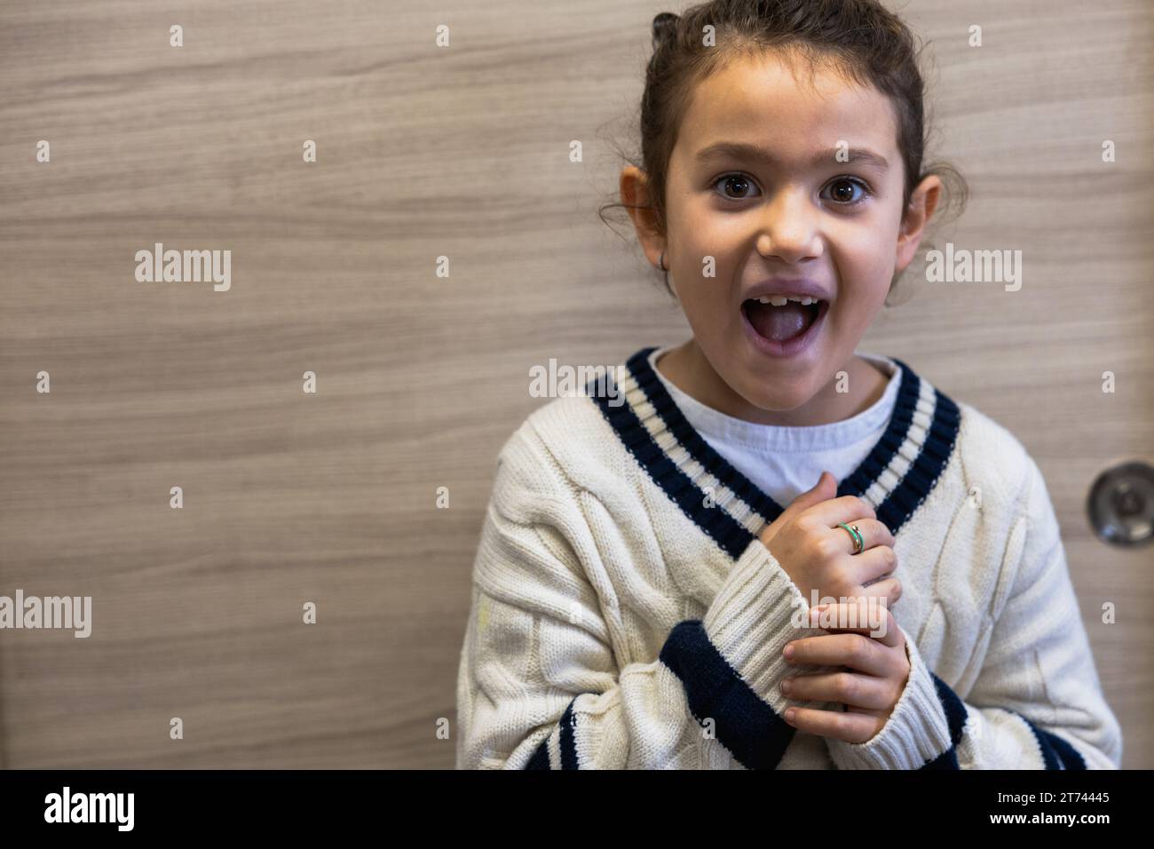 Portrait d'une petite fille posant sur la caméra avec une expression surprise, espace blanc Banque D'Images