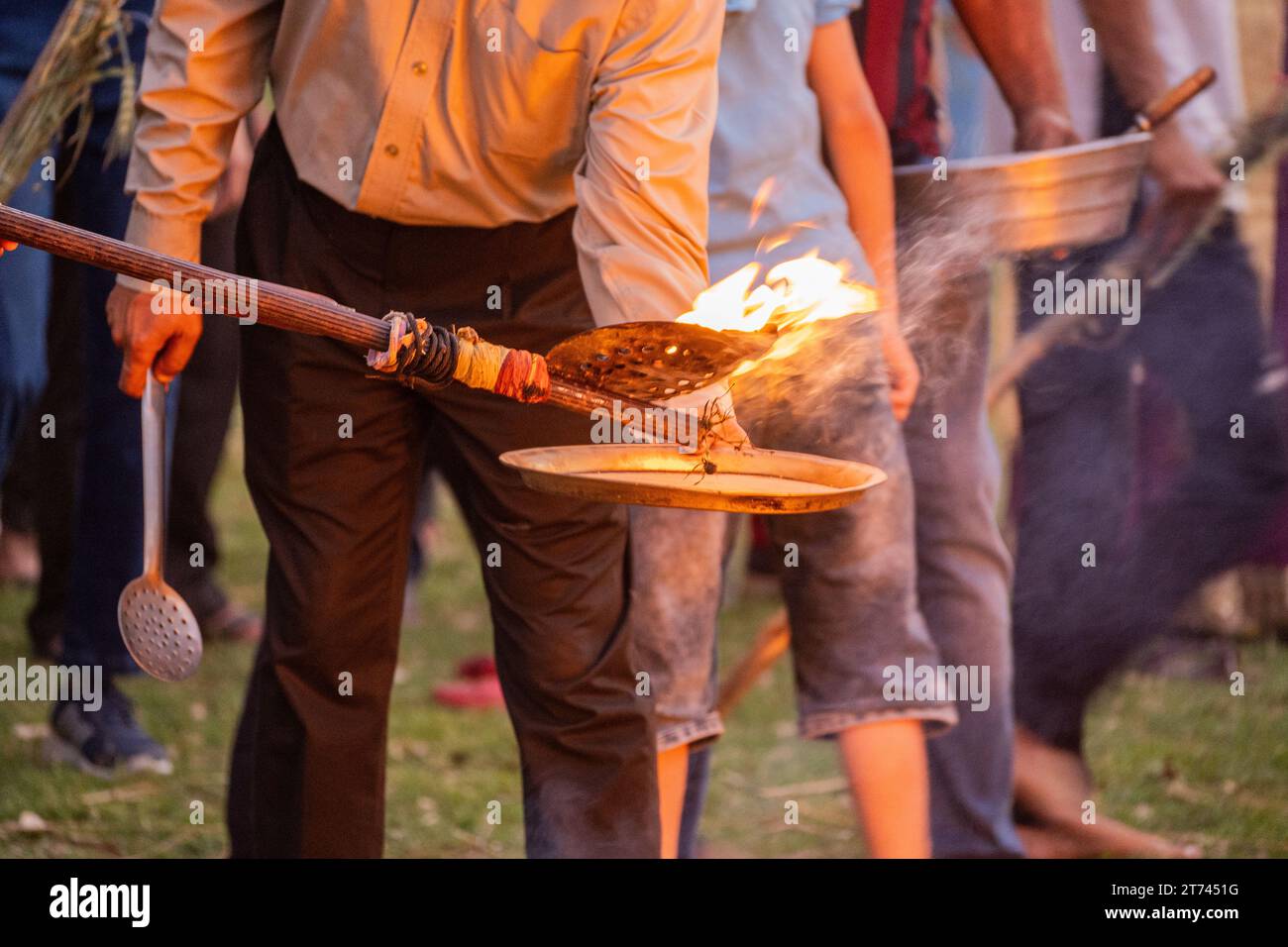 Les gens utilisant des plaques perforées pour recueillir des charbons, des gâteaux de bouse de vache, du gramme de blé rôti sur holi lohri Banque D'Images