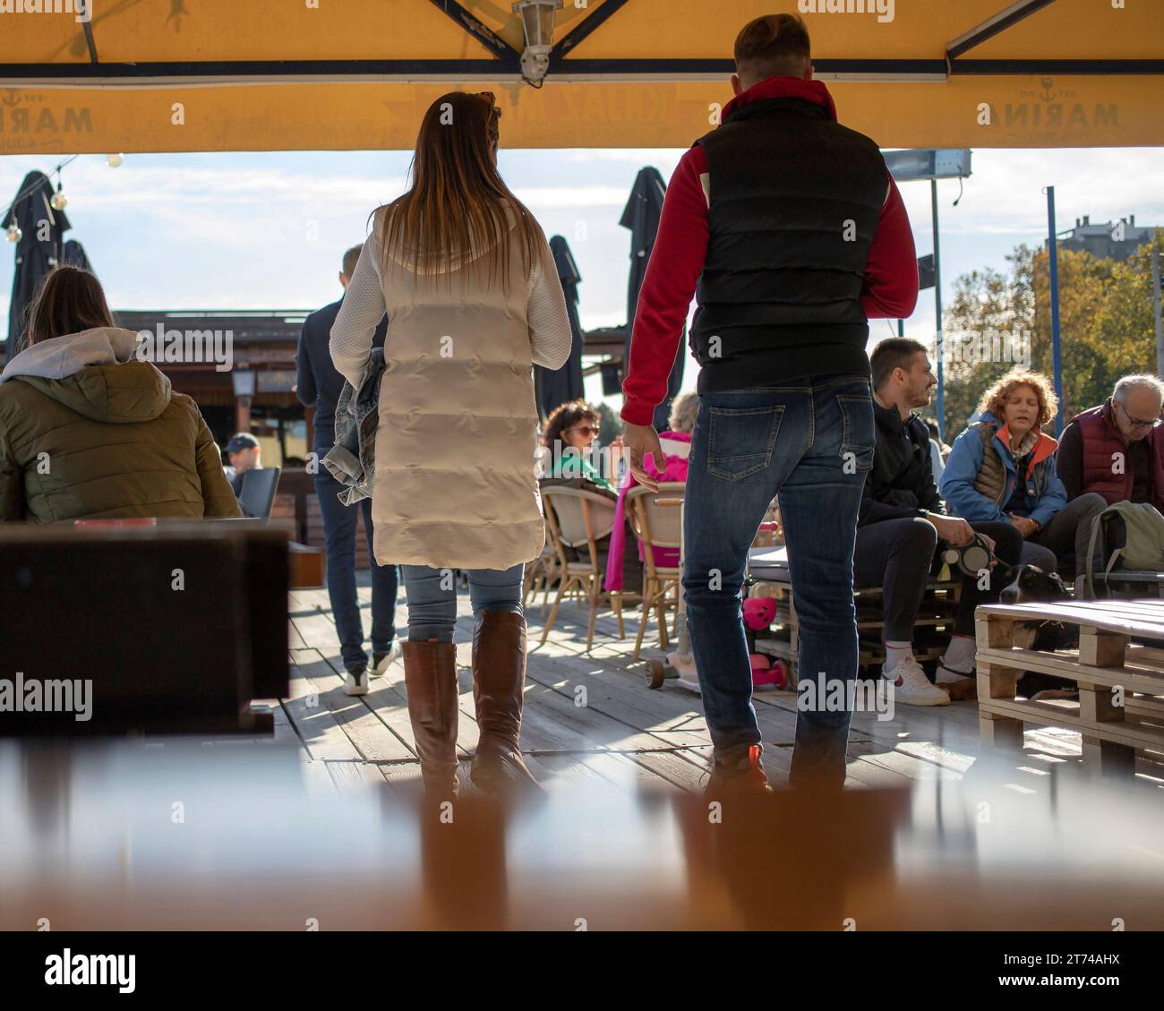 Belgrade, Serbie, 12 novembre 2023 : couple entrant dans une terrasse de restaurant placée sur un pont de barge ancré sur le Danube Banque D'Images