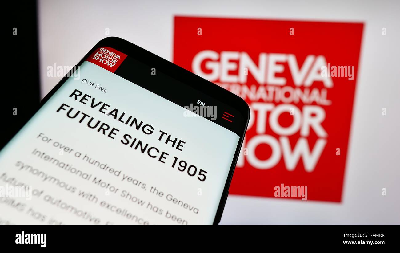 Téléphone portable avec site Web du salon suisse de l'auto Genève salon international de l'automobile devant le logo de l'entreprise. Effectuez le focus sur le coin supérieur gauche de l'écran du téléphone. Banque D'Images