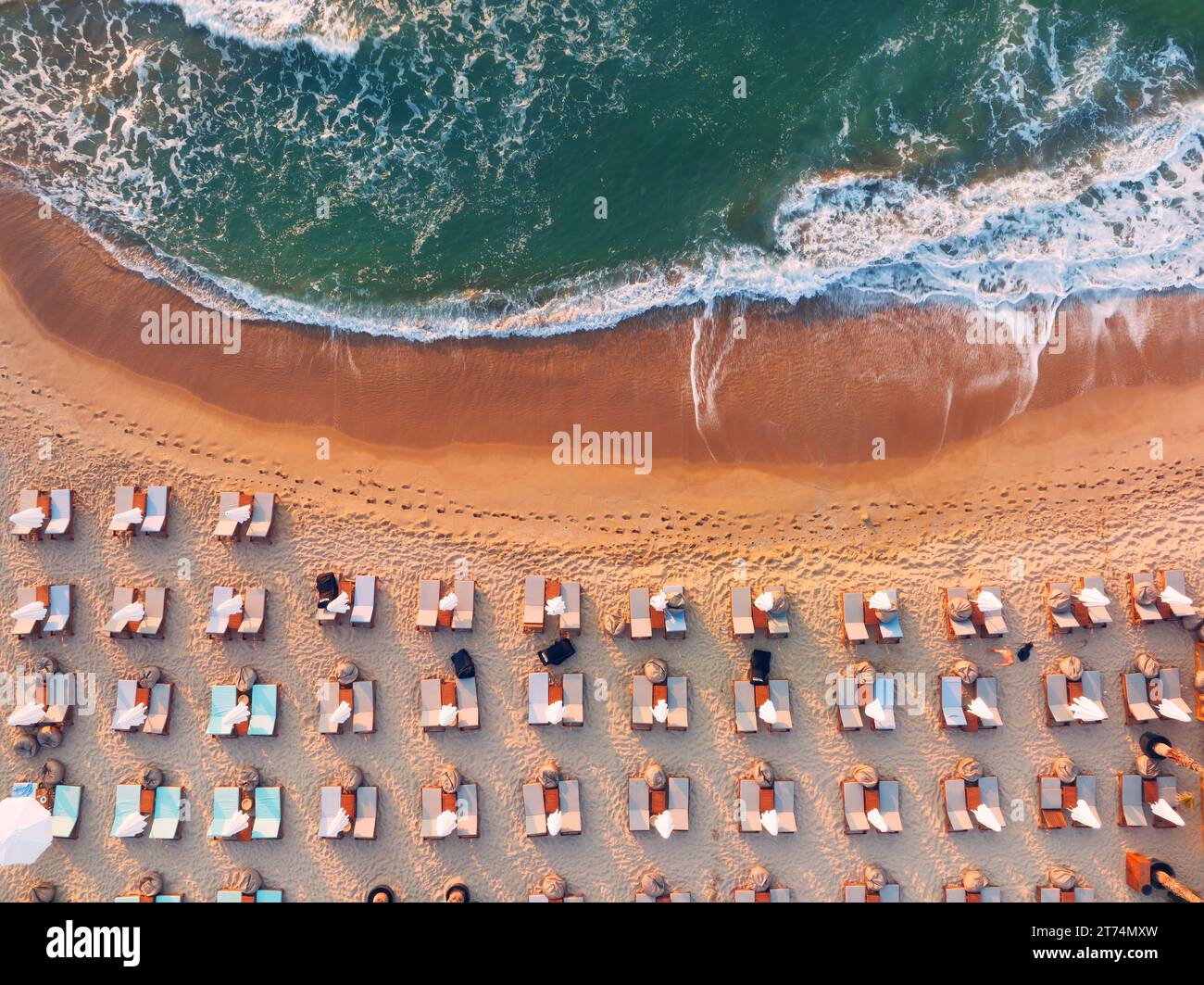 Vue aérienne de dessus sur le rivage de la plage et la mer. Parapluies, sable et vagues de mer Banque D'Images