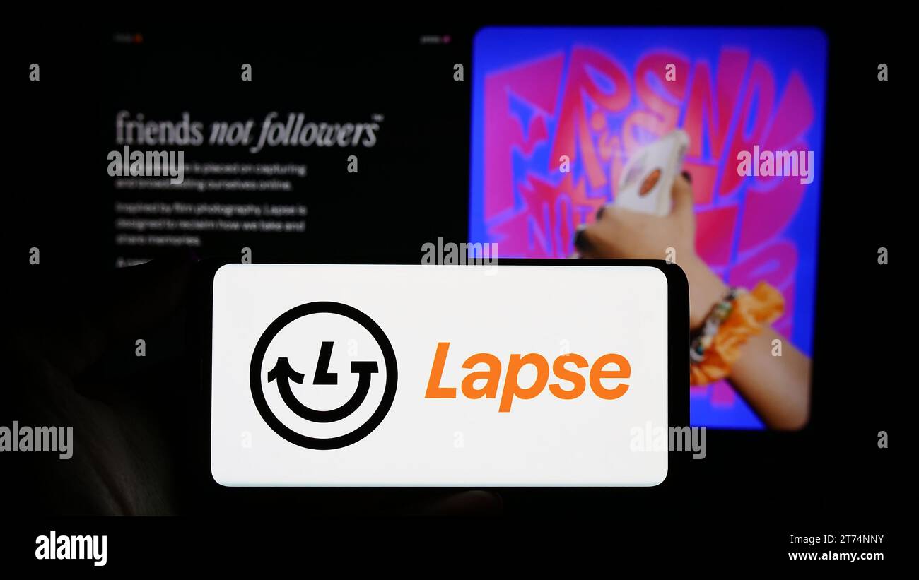 Personne tenant le smartphone avec le logo de l'application d'appareil photo jetable lapse devant le site Web. Concentrez-vous sur l'affichage du téléphone. Banque D'Images