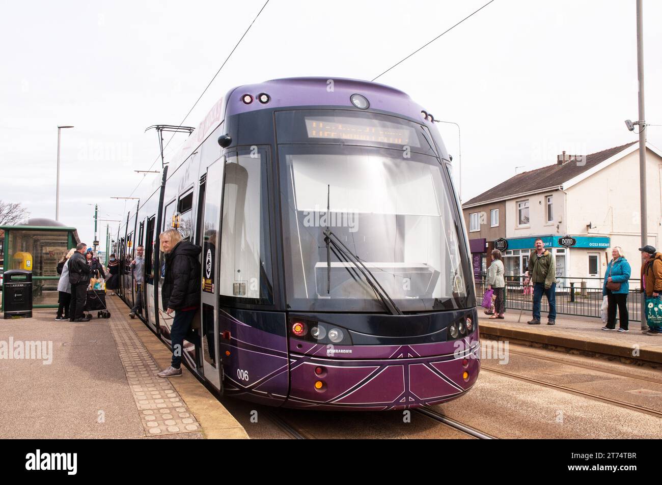Les gens qui attendent pour prendre le tram n ° 006 à Blackpool avec les gens descendent à Cleveleys Lancashire Angleterre les gens attendent de l'autre côté pour le tram Fleetwood Banque D'Images